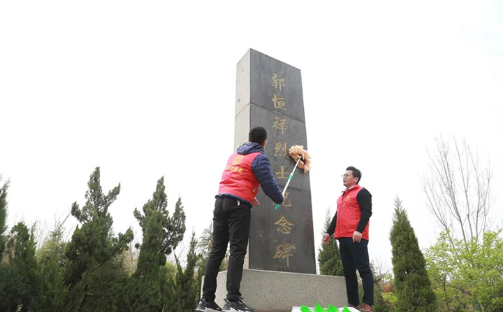 職工志愿者對(duì)紀(jì)念碑進(jìn)行清理、擦拭.jpg